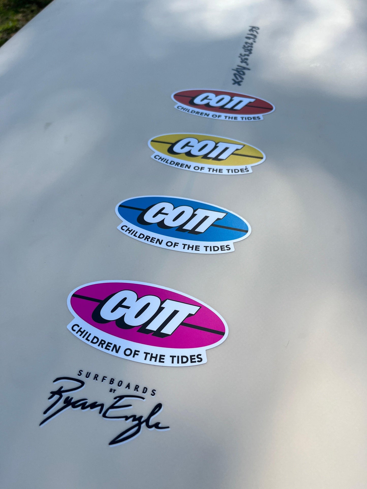 COT surfboard stickers in red, yellow, blue, pink on white board, Ryan Eyle signature, Children of the Tides design